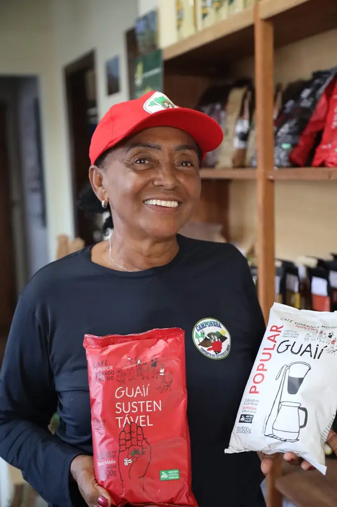 Cooperada apresentando pacotes de café torrado e moído